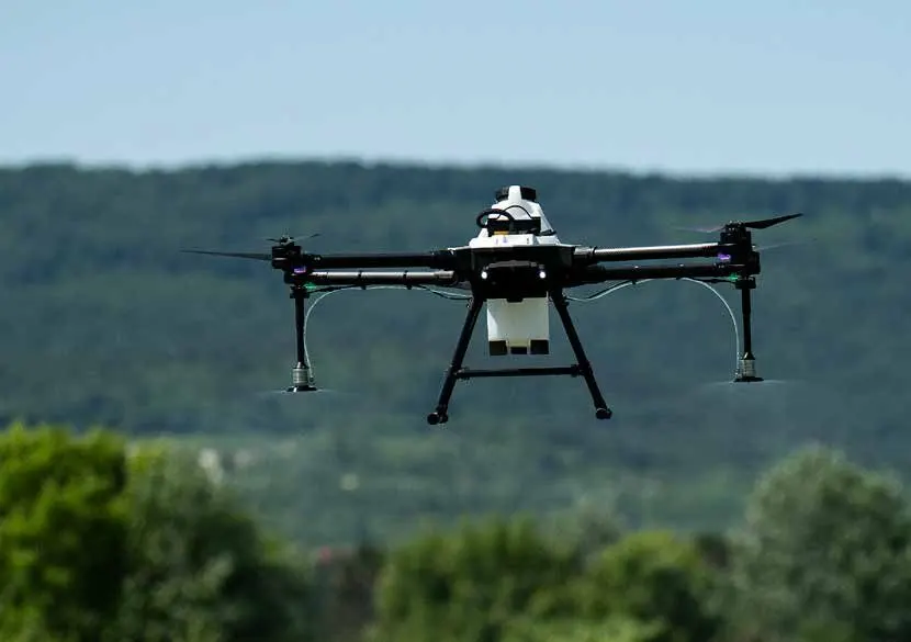 An ABZ drone hovering over a green landscape