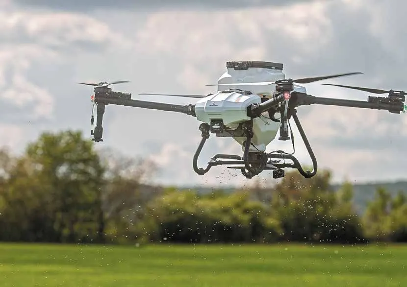 An ABZ spreading drone releasing granules over grass